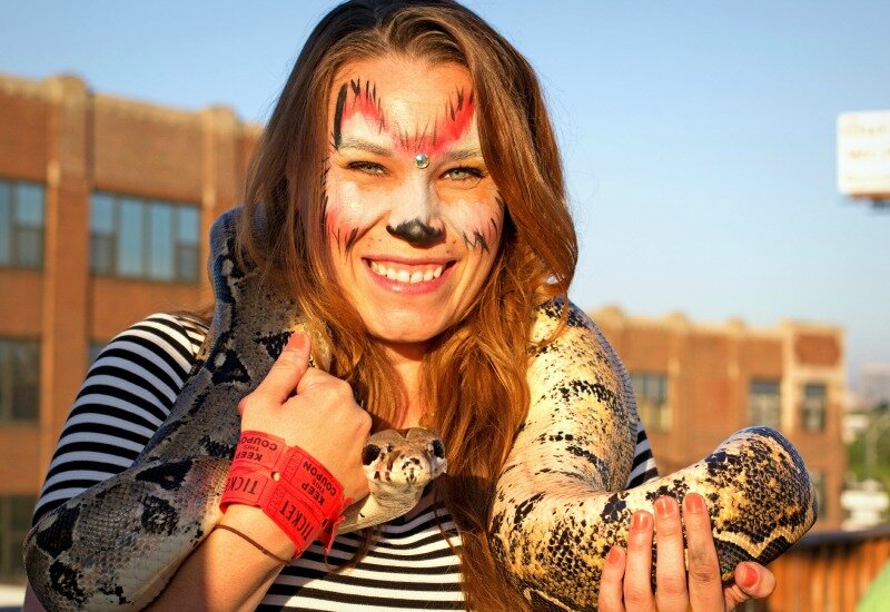 Jessica holds a boa constrictor on her shoulders.